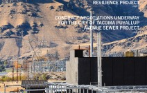 Construction workers at hydrogen facility at the base of dirt hills.