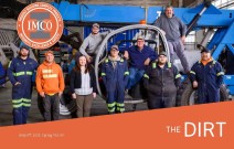 Team of shop staff posing on a blue crane in IMCO shop.
