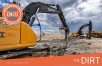 Yellow tractors crushing rocks in dirt construction site