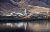 white batch plant with water and brown hills in background