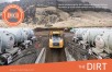 White tank trucks lined outside of a yellow dump truck
