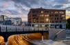 Yesler bridge and Seattle roadway with cloudy sunset sky and brick building in background 