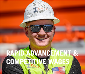 IMCO Construction employee with hardhat standing smiling with glasses and mud in face