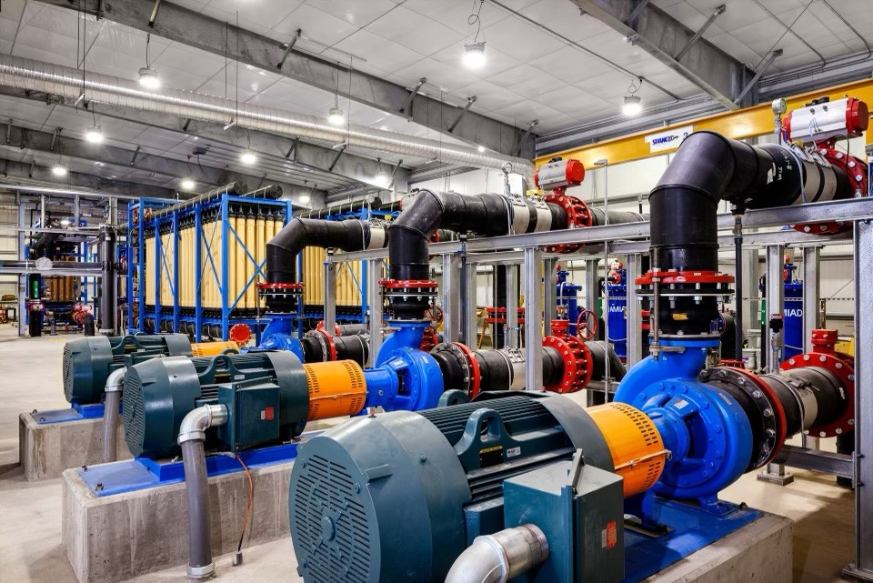 Blue and orange systems with black piping and red fittings inside industrial building