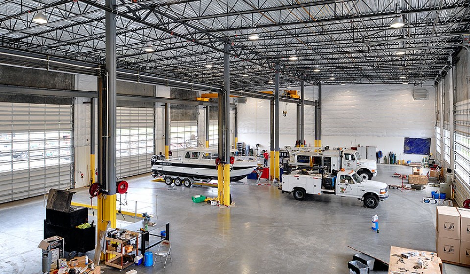 Interior of large shop with trucks and a boat