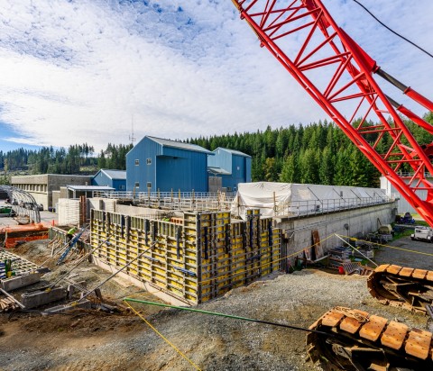 Red crane over blue buildings in construction site