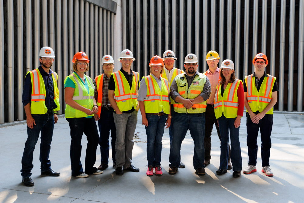 Group of people standing together wearing hard hats and high vis vests