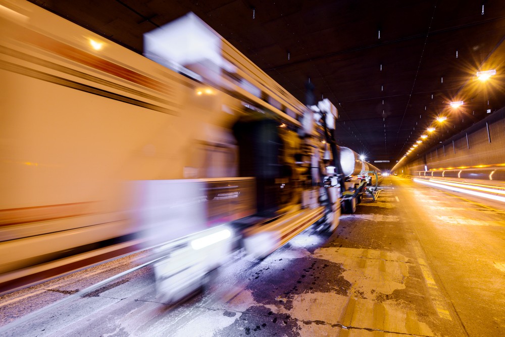 Blurred construction vehicle on a raodway at night with dramatic lighting 