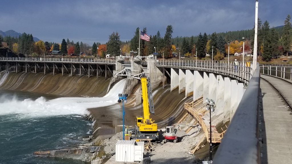 yellow crane in a dam with the American flag above a waterfall
