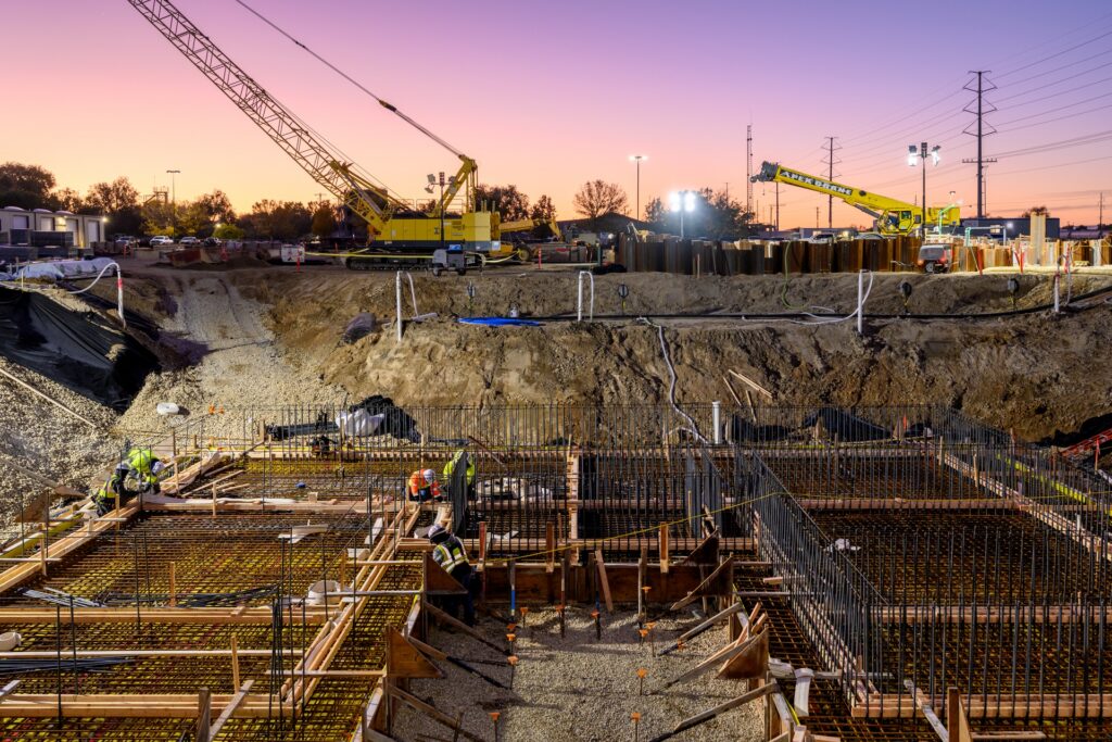crane over deep excavated worksite and sunset sky
