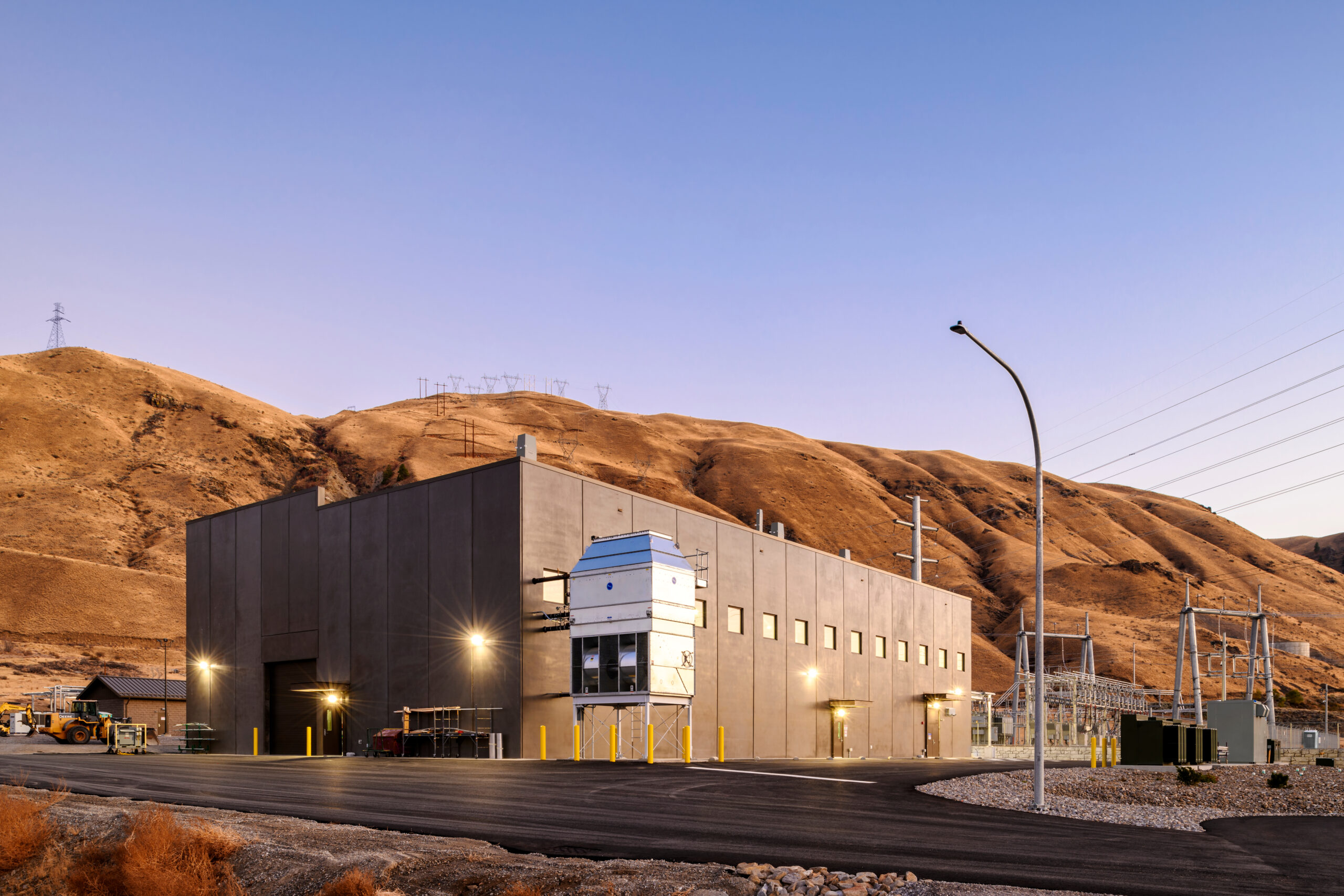 Concrete building at dusk surrounded by dirt hillsides